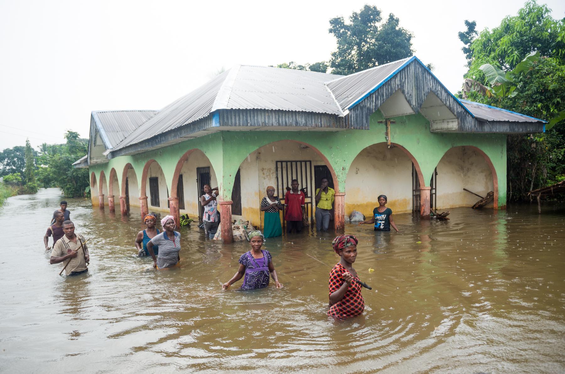 People wading through water flooding. Photo.